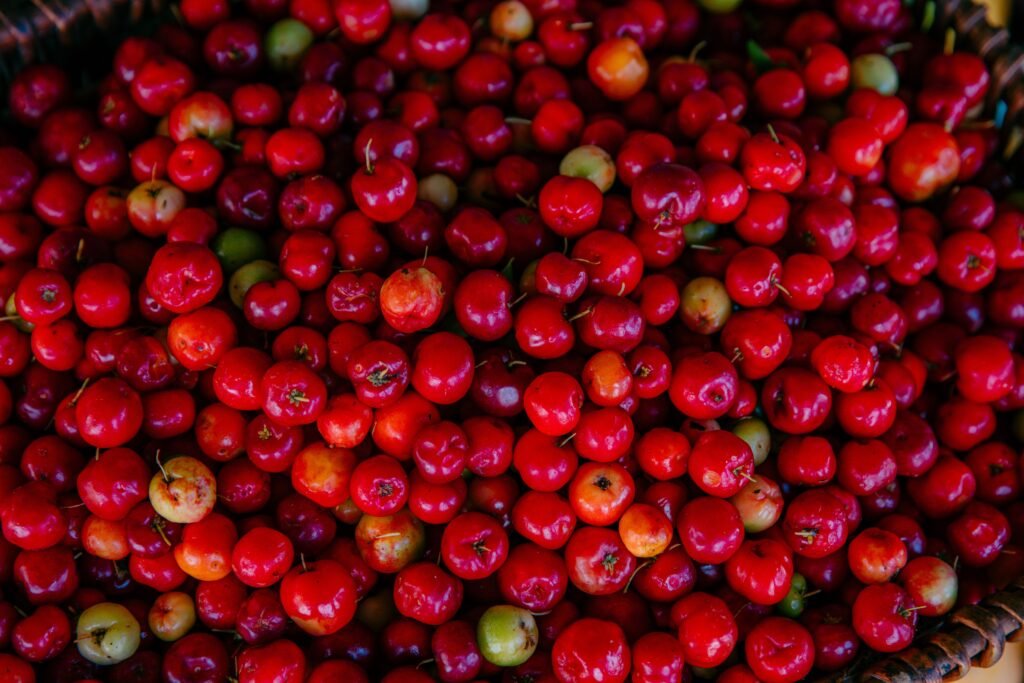 a basket filled with lots of red cherries